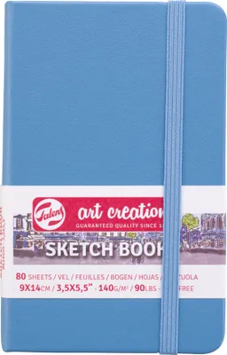 A blue sketchbook with a paper band around it, showing product details and branding.