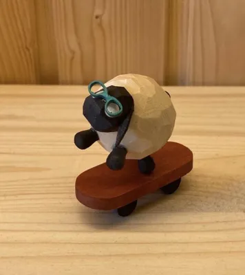 Imagen del producto de Figura de madera de una oveja en un monopatín, color claro, altura de 3,5 cm. Producto nuevo