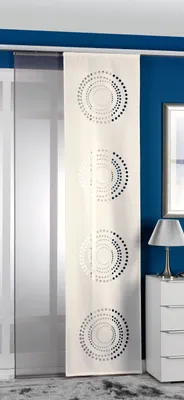 A sliding curtain with a circular pattern hangs in front of a closet.