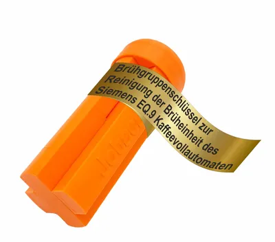 An orange cleaning tool for a coffee machine, with a gold label wrapped around it.