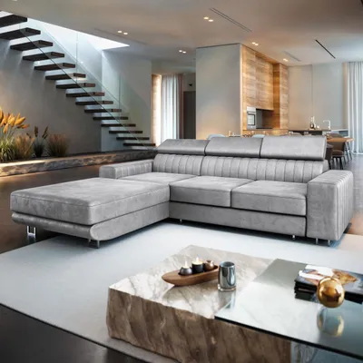 A modern living room with a large sectional sofa, a unique coffee table, and a staircase.