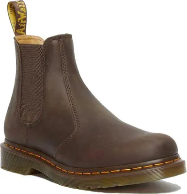 A single brown Dr. Martens Chelsea boot is shown against a white background.