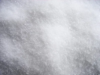A close-up, textured view of white, granular material, likely artificial snow.