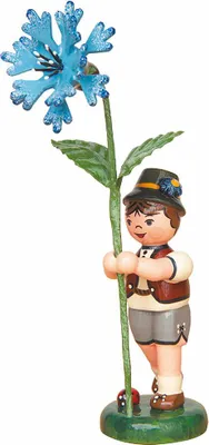 A wooden figurine of a boy holding a blue flower.
