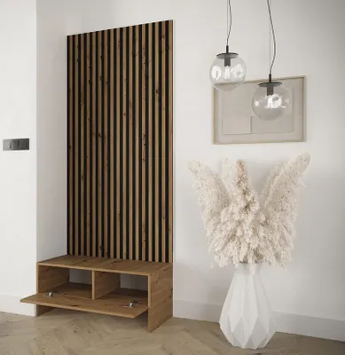 A modern entryway with a wooden slatted panel and a bench with storage, decorated with a large vase of dried flowers.