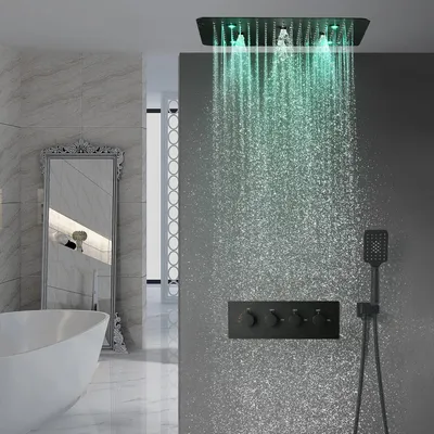 A modern bathroom with a bathtub, mirror, and a shower system with LED lights.