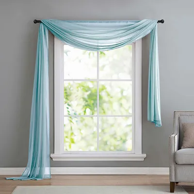 A light blue sheer scarf draped over a window.