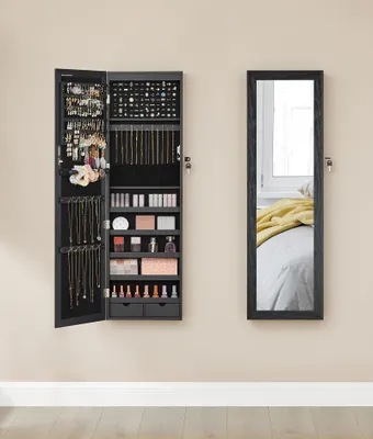 A wall-mounted jewelry cabinet with its door open, displaying various jewelry and cosmetics, next to a full-length mirror.