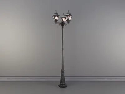 A black, three-headed street lamp stands against a plain, light gray wall.