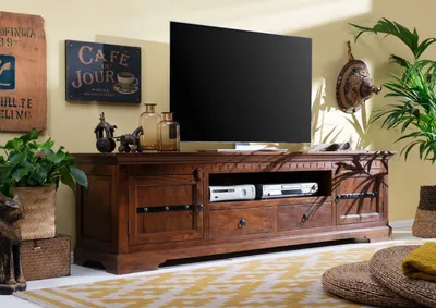 A living room scene featuring a wooden TV stand with a television and decorative items.