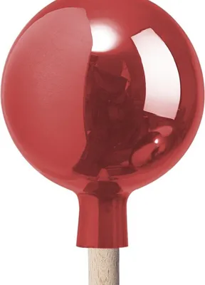 A close-up of a red glass ball ornament on a wooden stick.