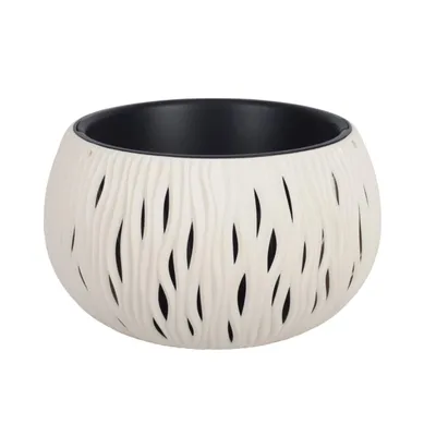 A white planter with a textured, wavy pattern and cutouts, revealing a black interior. The planter is shown against a plain white background.