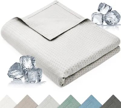 A folded light gray blanket with a waffle weave texture is shown, with ice cubes placed around it to suggest a cooling effect. Below the blanket, swatches of different colored blankets are displayed.