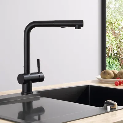 A black kitchen faucet is shown in a modern kitchen setting, with a sink and a window in the background.