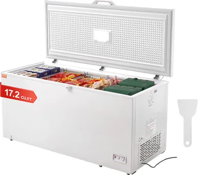 An open chest freezer filled with food, with a white spatula on the right side.
