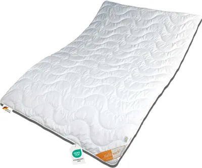 A white duvet with a wavy pattern, lying diagonally on a white background. It has tags attached to one corner.