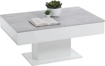 A coffee table with a concrete-look top and white base, decorated with two small plants and an open book.