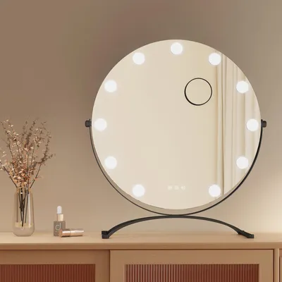 A round makeup mirror with lights on a wooden dresser.