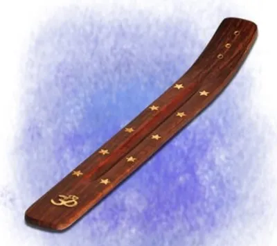 Ein Räucherstäbchenhalter aus dunklem Holz, der mit goldenen Sternen und dem Om-Symbol verziert ist.