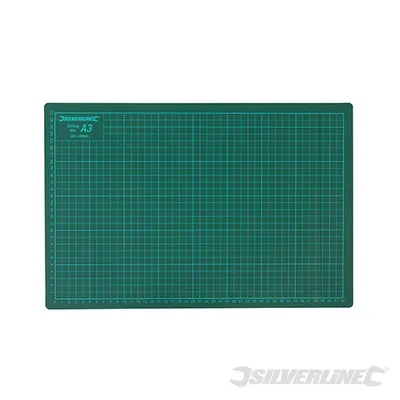 A green cutting mat with grid lines and measurements is shown on a white background.