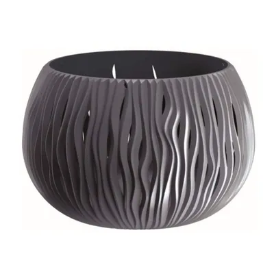 A gray, round planter with a wavy, cut-out design sits on a white background.