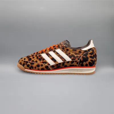 A side view of a single Adidas sneaker with a leopard print pattern.
