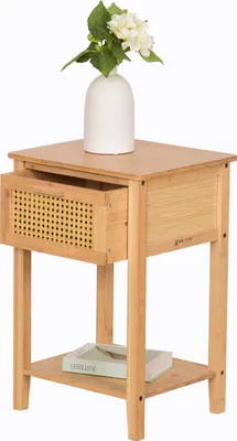 A wooden nightstand with a drawer and a shelf, topped with a white vase holding white flowers.