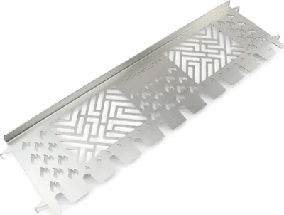 A silver metal grill accessory with intricate cutouts and a branded website address.
