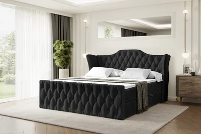 A bedroom setting with a black upholstered bed as the main focus.