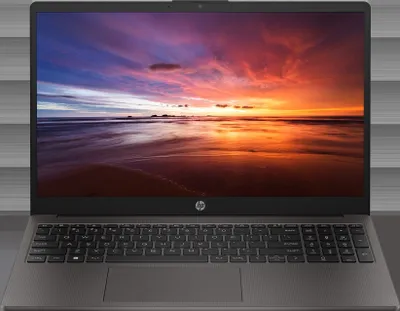 A laptop with a sunset wallpaper on its screen.