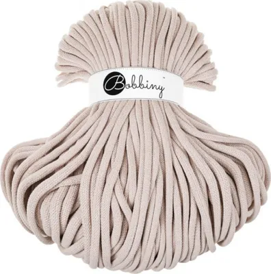 A spool of Bobbiny Jumbo cord in a nude color.