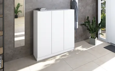 A white three-door cabinet is shown in a hallway or entryway setting.