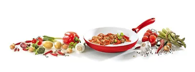 A collection of fresh ingredients arranged around a frying pan containing food.