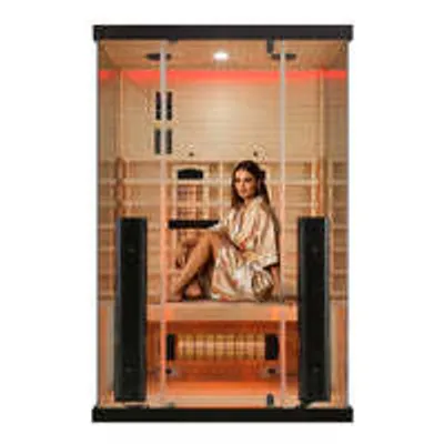 A woman sits inside an infrared sauna.