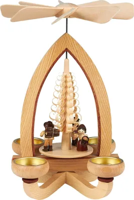 Auf dem Bild ist eine hölzerne Teelichtpyramide mit einem spiralförmigen Baum in der Mitte und drei kleinen Figuren zu sehen die um den Baum herum angeordnet sind und von vier Teelichthaltern umgeben werden