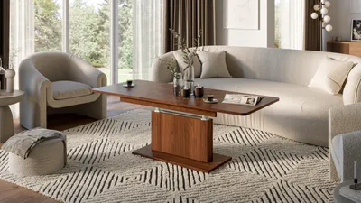 A modern living room with a curved sofa, armchair, and a wooden coffee table. A patterned rug is on the floor.