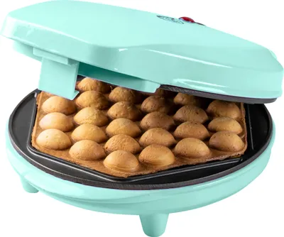 A mint-colored bubble waffle maker with freshly baked bubble waffles inside.