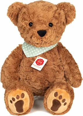 A brown teddy bear with a green polka dot bandana and a red tag.