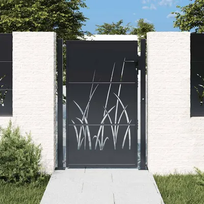A dark gray metal garden gate with a grass design, set between two white stone pillars, with a pathway leading to it and greenery around.