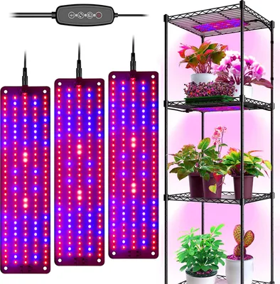 A plant grow light setup with three LED panels and a multi-shelf plant stand.