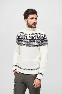 A man wearing a white and black patterned sweater.