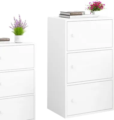 Two white storage cabinets are shown against a white background. One cabinet is on the left and is partially visible, while the other is on the right and is fully visible. The cabinet on the right has three shelves, each with a door. A small vase with purp