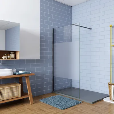 A modern bathroom with blue tiled walls and a glass shower enclosure.