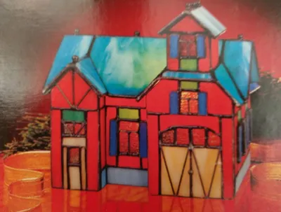 Ein kunstvolles, rot-blaues Tiffany-Haus, das eine Feuerwehrwache darstellt. 