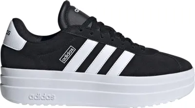 A studio shot of a black Adidas sneaker with white stripes and a thick white sole.