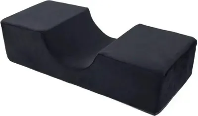A black U-shaped pillow for eyelash extensions.