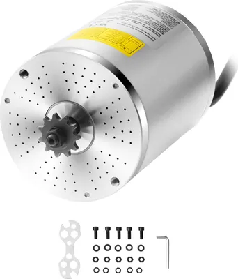 A close-up, angled view of a silver electric motor with a sprocket attached to the shaft. Below the motor are various accessories including bolts, nuts, a wrench, and an Allen key.