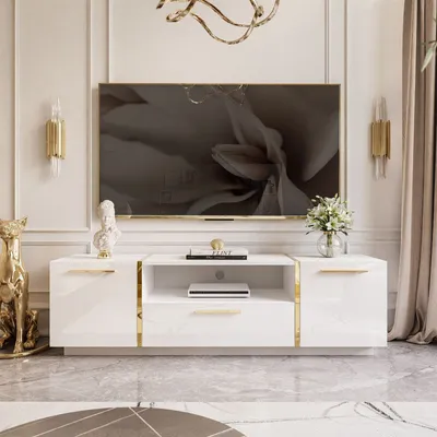 A white TV stand with gold accents, featuring a large television, decorative items, and a gold cat statue.