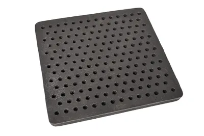 A square cast iron grate with many small holes, presented on a white background.