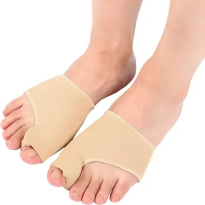A close-up shot of two feet wearing beige toe separator socks.